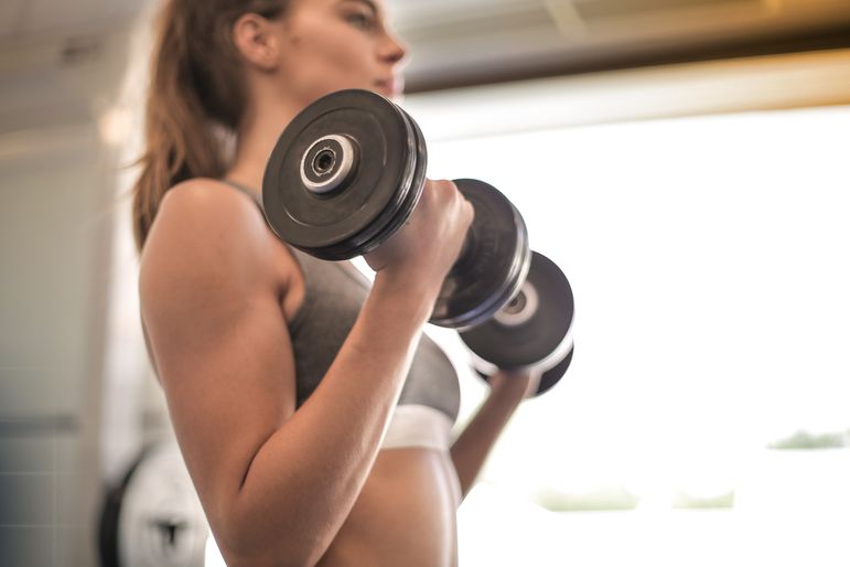 Vrouw traint actief in een lichte, moderne fitnessruimte