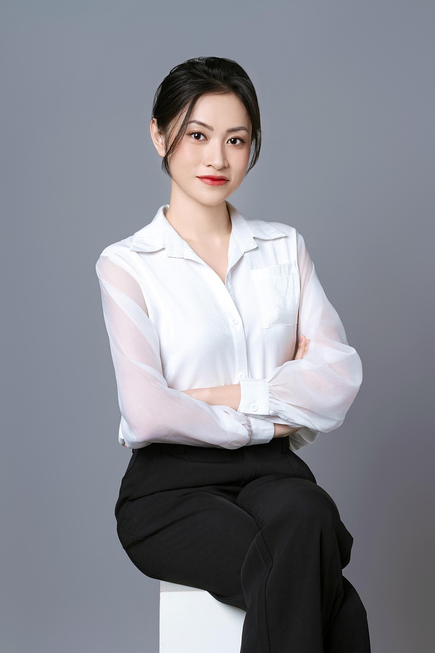 Portret van een professionele vrouw met een stralende, egale huid in een witte blouse